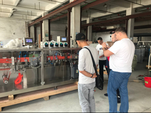 Pelanggan Rusia mengunjungi dan memeriksa ampul plastik minyak zaitun yang membentuk mesin penyegel di pabrik